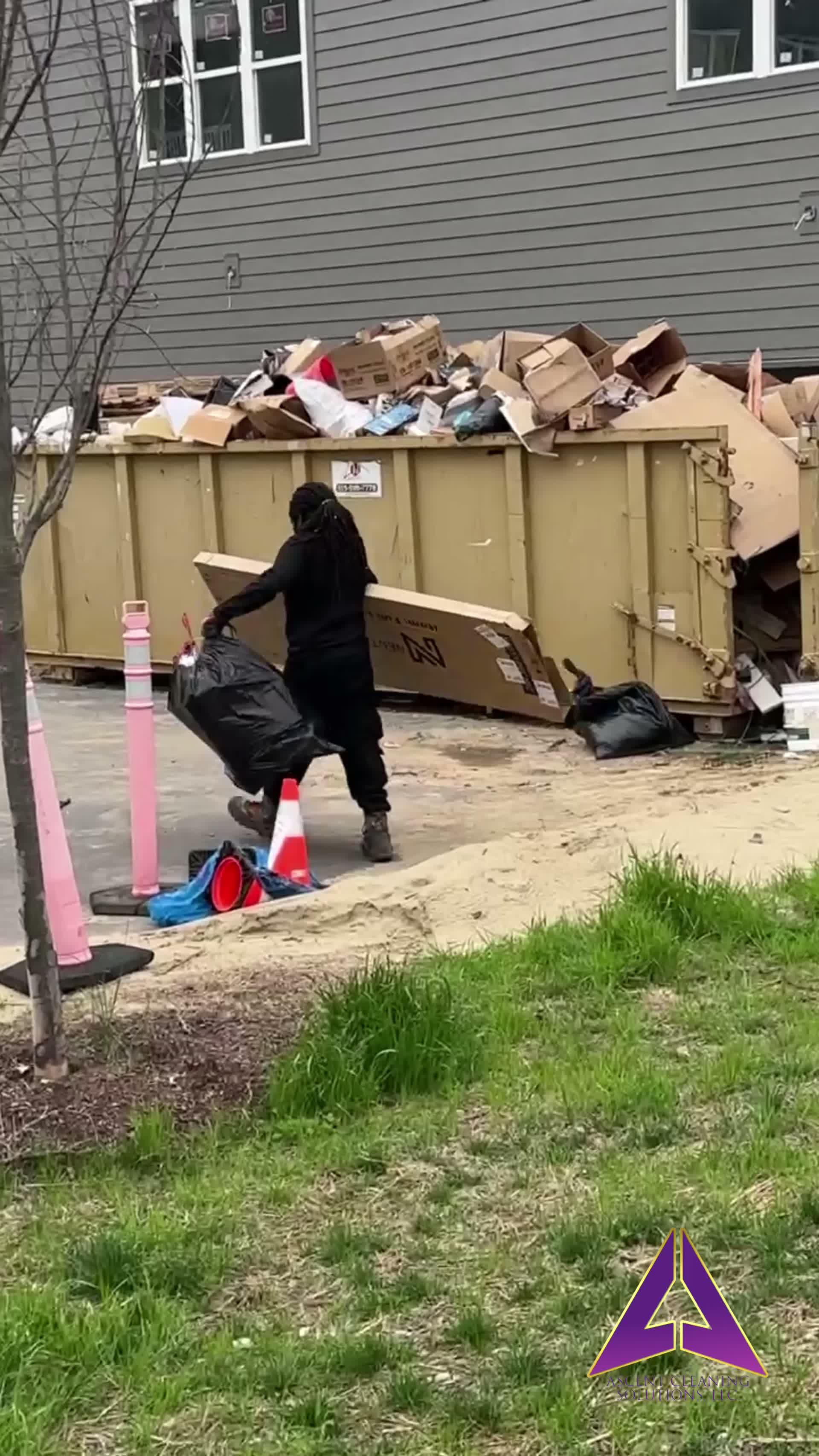 ACS team member loading construction debris into dumpster on Nashville job site